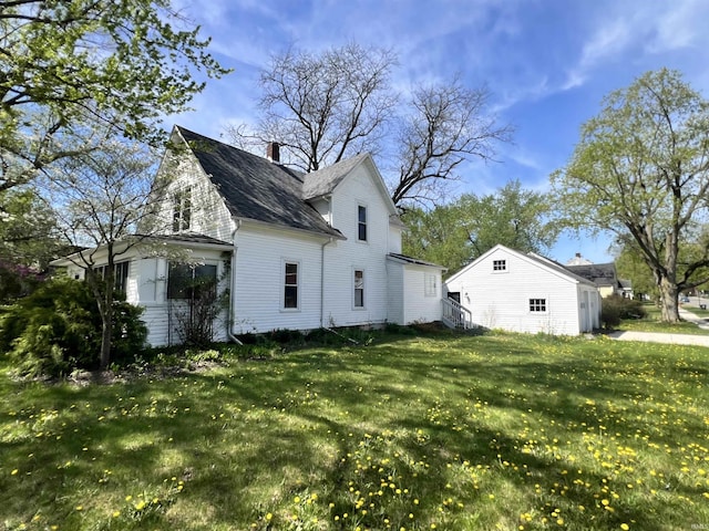 view of side of home featuring a lawn and a chimney