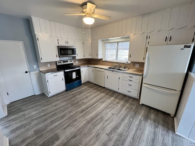 kitchen featuring a sink, wood finished floors, white appliances, white cabinets, and a ceiling fan