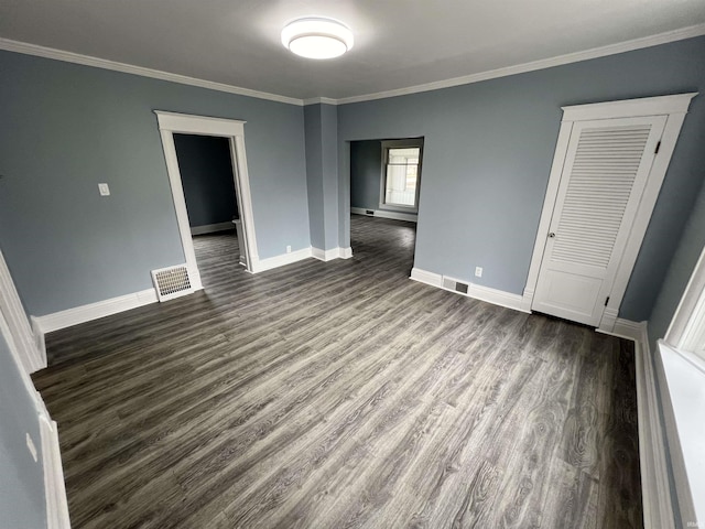 interior space with baseboards, ornamental molding, dark wood-style flooring, and visible vents