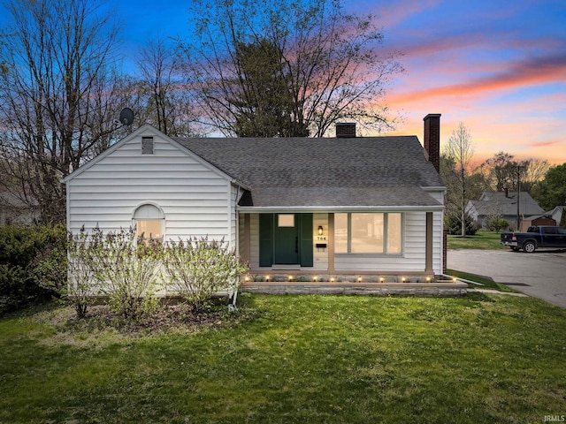 706 Ruse St, North Manchester, IN 46962 - view of front of house with covered porch, a chimney, roof with shingles, and a front lawn