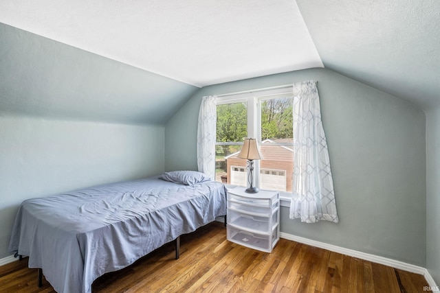706 Ruse St, North Manchester, IN 46962 - bedroom featuring baseboards, a textured ceiling, wood finished floors, and lofted ceiling