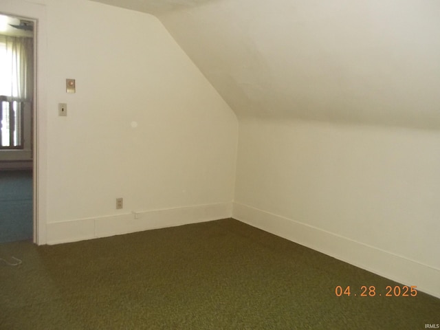 additional living space with vaulted ceiling and dark carpet