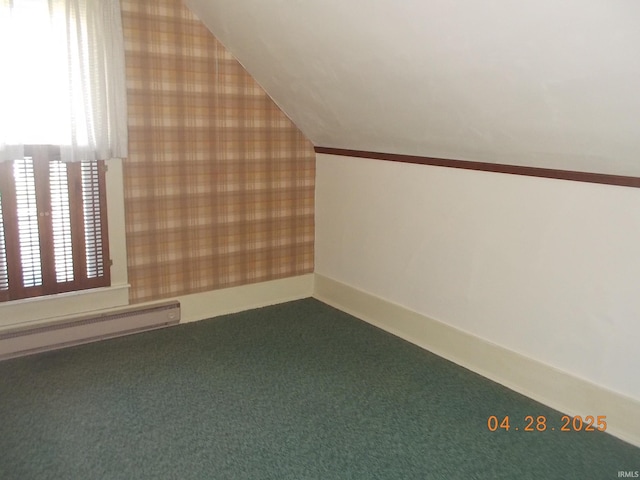 additional living space with carpet floors, baseboards, wallpapered walls, a baseboard heating unit, and vaulted ceiling