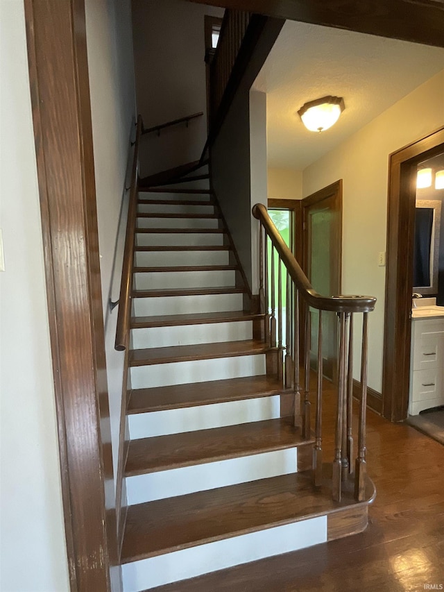 stairway featuring baseboards and wood finished floors