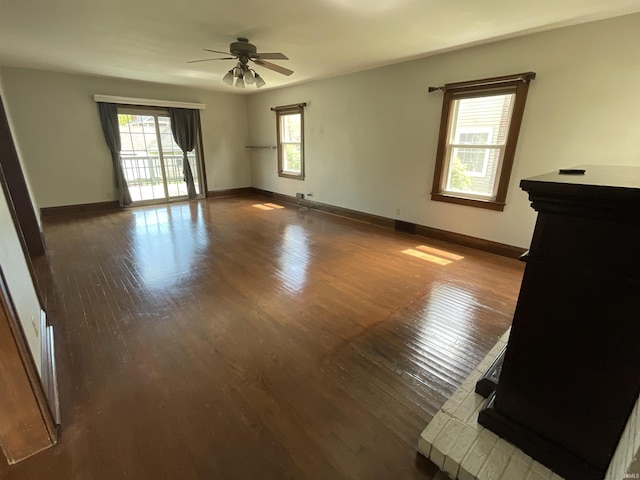 empty room with a healthy amount of sunlight, ceiling fan, and wood finished floors
