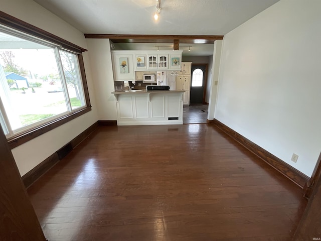 interior space featuring track lighting, baseboards, and dark wood-style floors