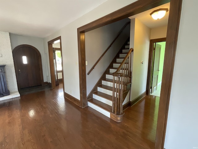 foyer entrance with stairs, baseboards, and wood finished floors