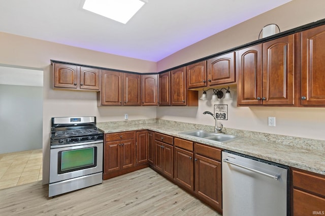 kitchen with a sink, appliances with stainless steel finishes, and light wood-type flooring