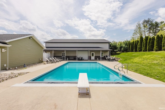 outdoor pool with a patio, a diving board, and a yard