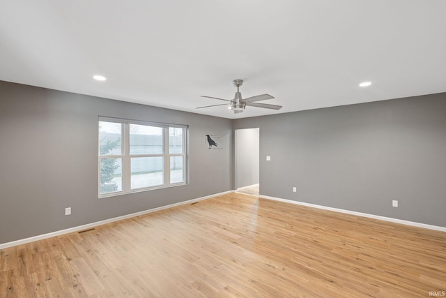 empty room featuring a ceiling fan, visible vents, light wood-type flooring, baseboards, and recessed lighting
