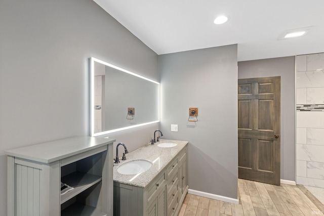 bathroom featuring a sink, baseboards, and wood finished floors