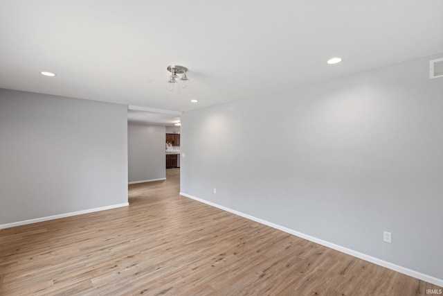 empty room featuring baseboards, recessed lighting, light wood finished floors, and visible vents