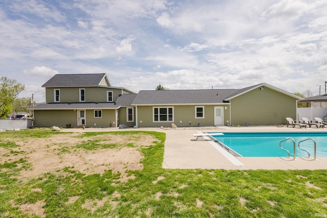 rear view of property featuring a fenced in pool, a patio area, and fence