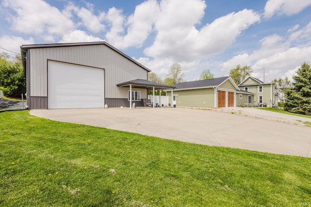 view of front facade with driveway, an outbuilding, and a front yard