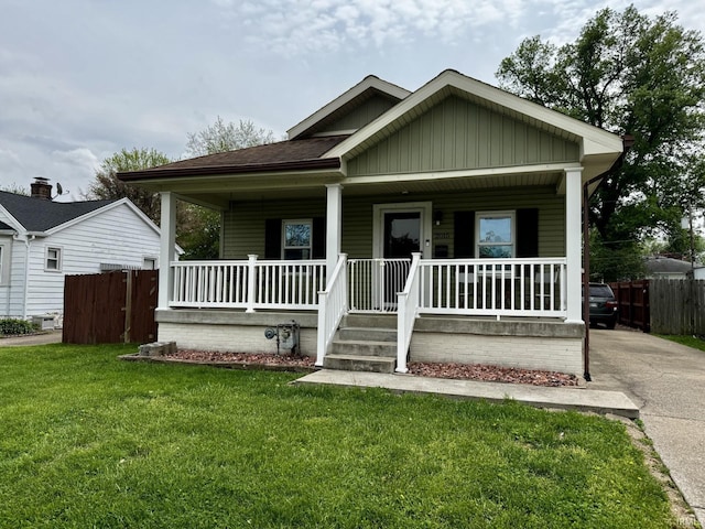 bungalow-style home with fence, board and batten siding, a porch, and a front lawn