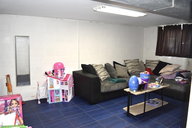 living room featuring concrete block wall and dark tile patterned flooring