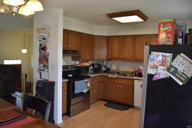 kitchen featuring appliances with stainless steel finishes, light wood finished floors, light countertops, brown cabinetry, and under cabinet range hood