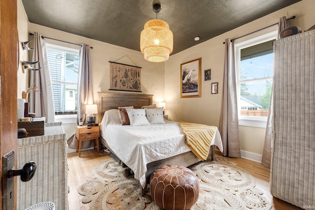 bedroom with baseboards and wood finished floors