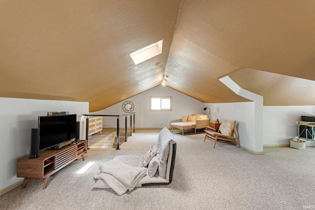 interior space with a textured ceiling, baseboards, carpet, and vaulted ceiling with skylight