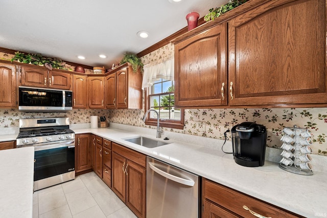 14157 Tenbury Dr, Granger, IN 46530 - kitchen with brown cabinetry, light tile patterned flooring, a sink, light countertops, and appliances with stainless steel finishes