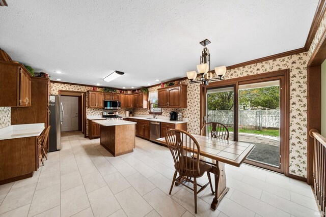 14157 Tenbury Dr, Granger, IN 46530 - kitchen with a center island, wallpapered walls, stainless steel appliances, plenty of natural light, and light countertops