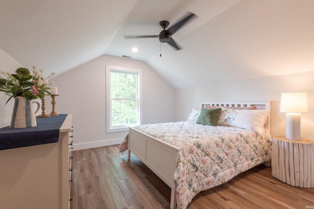 bedroom with ceiling fan, baseboards, lofted ceiling, light wood-type flooring, and visible vents