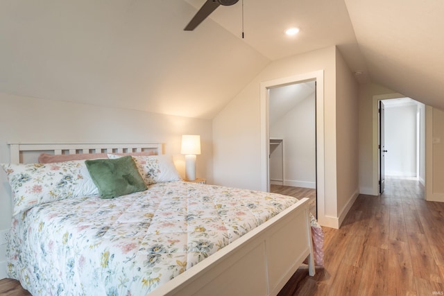 bedroom featuring a ceiling fan, vaulted ceiling, and light wood-type flooring