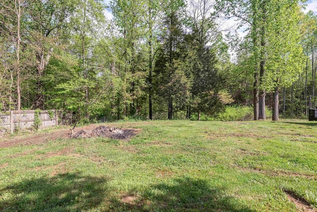view of yard with a view of trees and fence