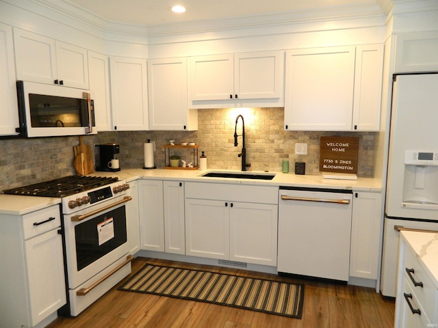 kitchen featuring a sink, white cabinetry, and white appliances