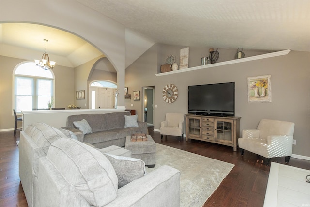 living room with arched walkways, dark wood finished floors, baseboards, a notable chandelier, and lofted ceiling