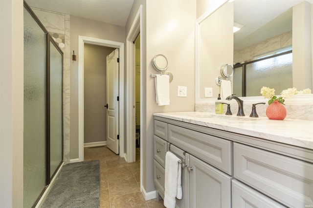 bathroom with vanity, tile patterned flooring, and a stall shower
