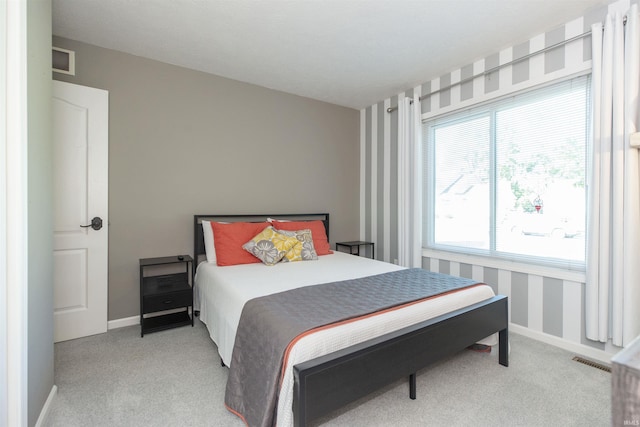 carpeted bedroom with visible vents and baseboards