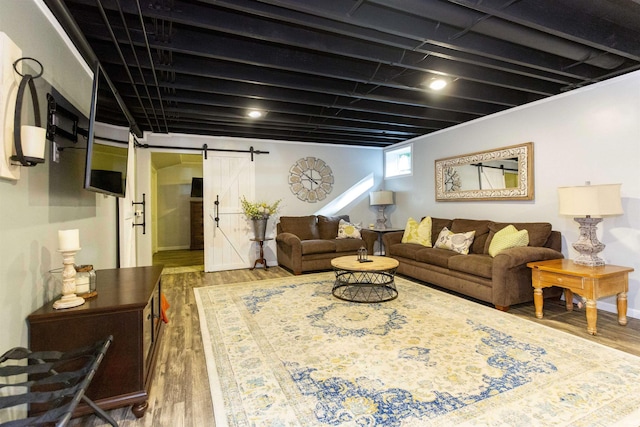 living area with a barn door and wood finished floors