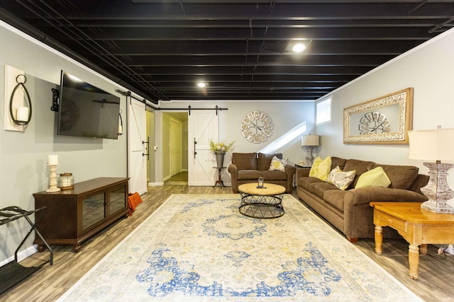 living room featuring baseboards, a barn door, and wood finished floors