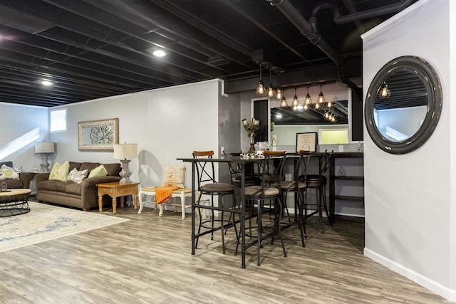 bar featuring baseboards, bar area, and wood finished floors