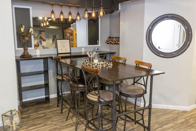 dining space featuring baseboards and wood finished floors