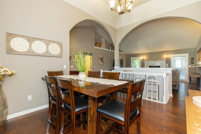 dining room with built in features, hardwood / wood-style floors, baseboards, a chandelier, and arched walkways