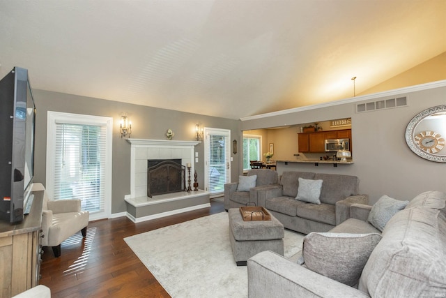 living room featuring vaulted ceiling, a healthy amount of sunlight, and visible vents