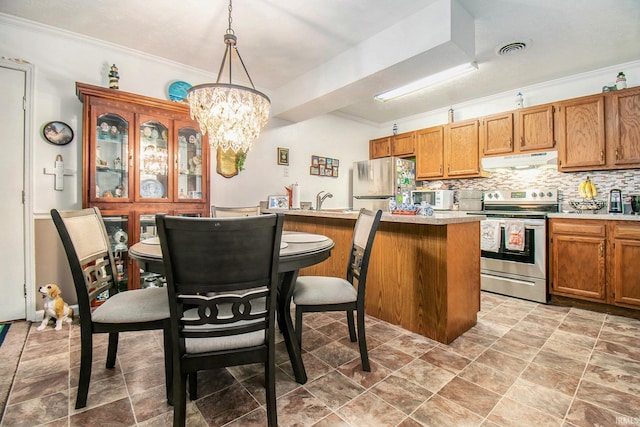 kitchen with freestanding refrigerator, light countertops, under cabinet range hood, a chandelier, and stainless steel electric stove