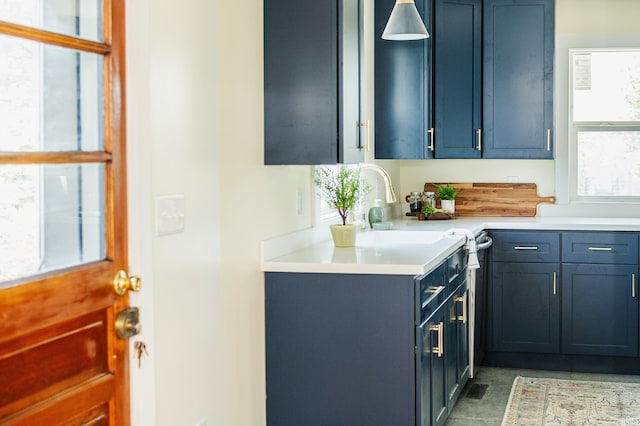 kitchen featuring light countertops, blue cabinetry, and a sink