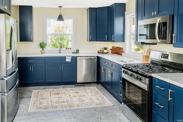 kitchen with plenty of natural light, a sink, blue cabinets, and stainless steel appliances