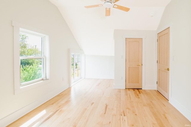 additional living space featuring light wood-style floors, a ceiling fan, baseboards, and vaulted ceiling
