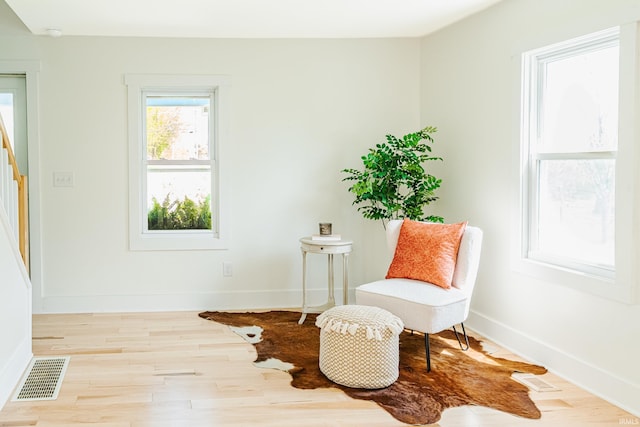 sitting room with baseboards, wood finished floors, and visible vents