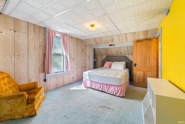bedroom with wooden walls and carpet flooring