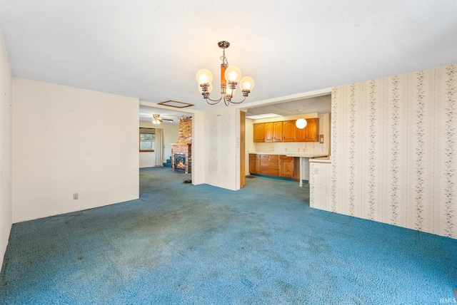 interior space with ceiling fan with notable chandelier, carpet, and a brick fireplace