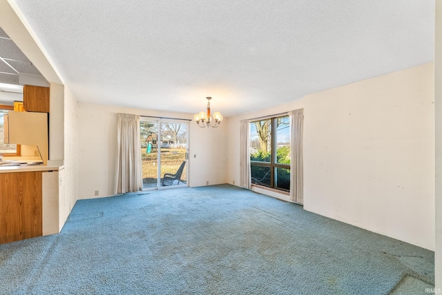 interior space featuring carpet floors, a textured ceiling, a chandelier, and a healthy amount of sunlight
