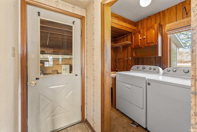 laundry area with wallpapered walls, cabinet space, baseboards, and washing machine and clothes dryer