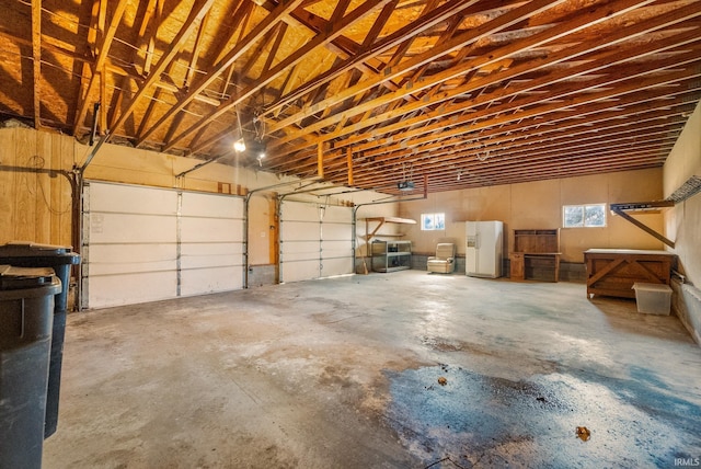 garage featuring white fridge with ice dispenser