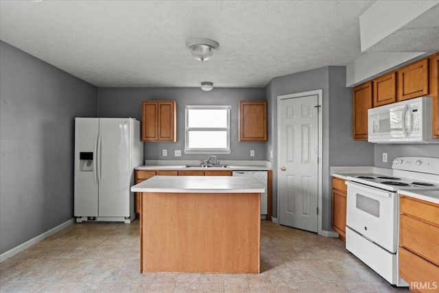 kitchen with brown cabinetry, a kitchen island, light countertops, baseboards, and white appliances