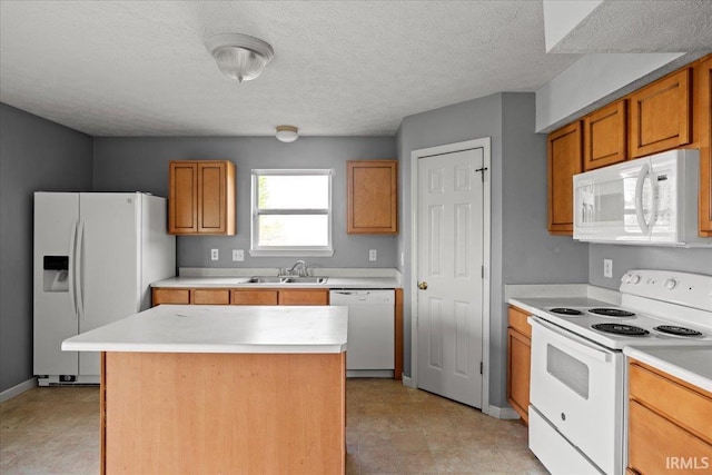 kitchen featuring white appliances, a center island, a sink, and light countertops
